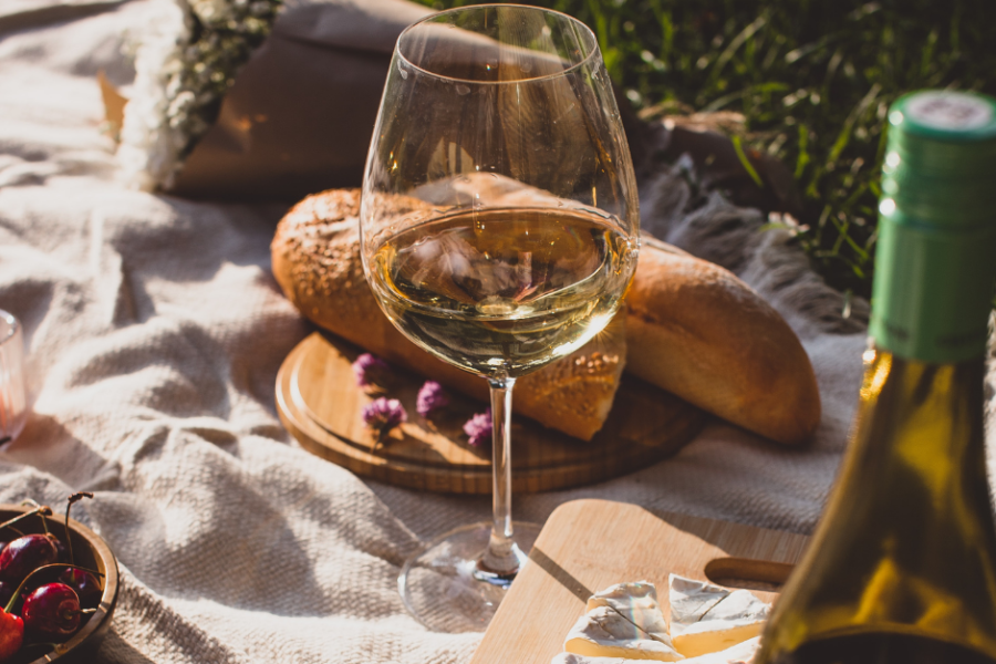 picnic with glass of wine, bread, flowers