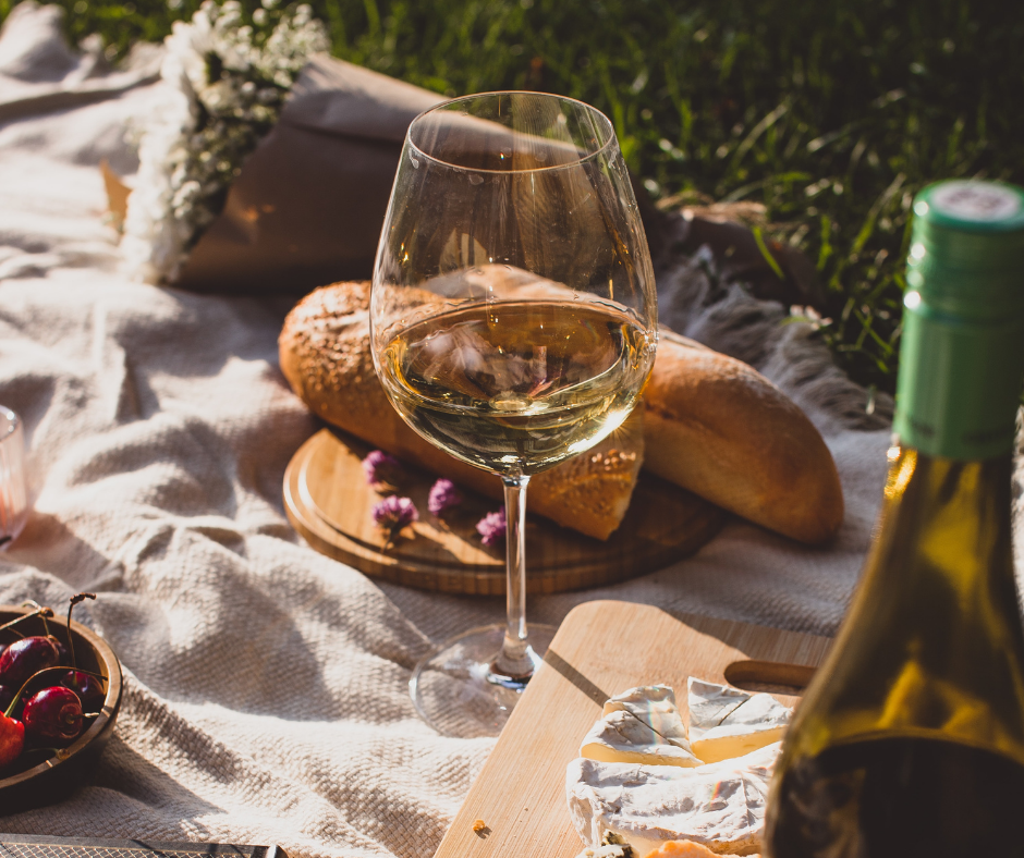 picnic with glass of wine, bread, flowers