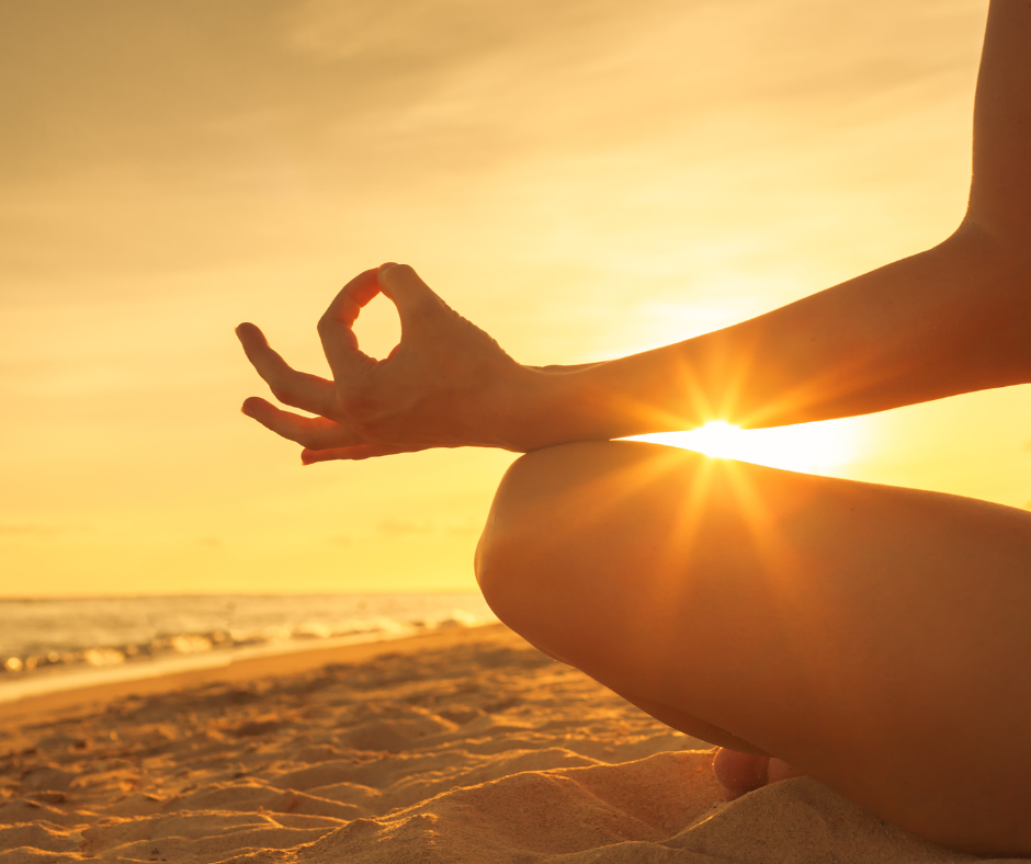 woman meditating on the beach