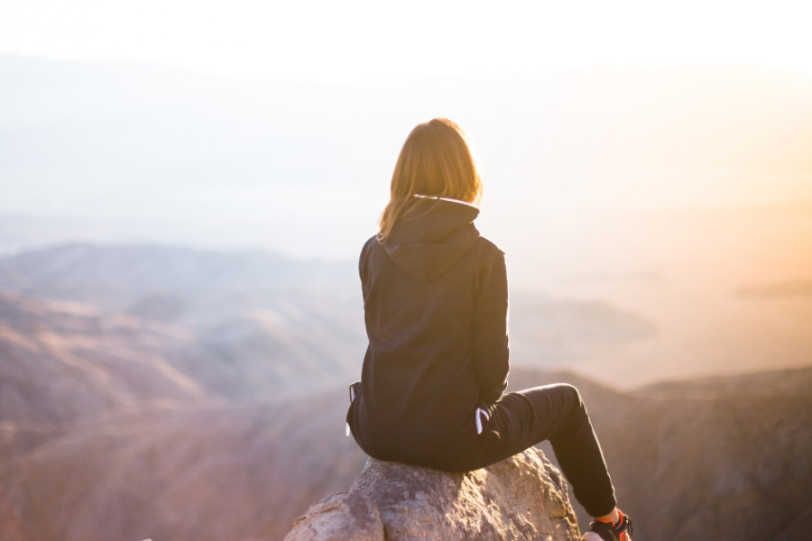 woman climbing a mountain peak